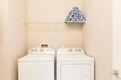 two white washing machines in a kitchen with a shelf at 5min Disney Wonderful Villa, BBQ, SMV102 in Orlando