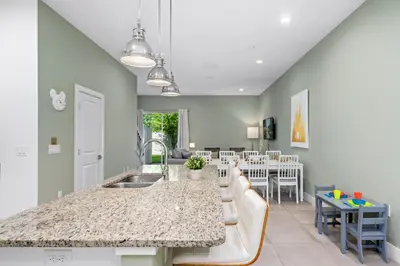 a kitchen and living room with a sink and a counter at 5min Disney Cozy Villa, BBQ Grill, SMV108 in Orlando