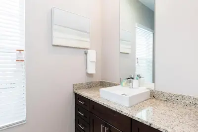 a bathroom with a sink and a mirror at 4 BR 4 BA Deluxe Villa 5 min to Disney Family getaway in Orlando