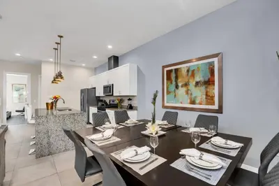 a dining room and living room with a table and chairs at 5 BR 6 BA Luxury Villa 5 min to Disneyworld Hot Tub & BBQ 112 in Orlando
