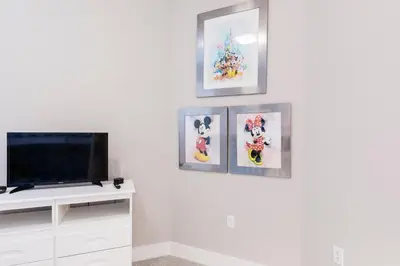 a living room with a tv and three pictures on the wall at 5min Disney Fantastic Family Villa SMV113 in Orlando