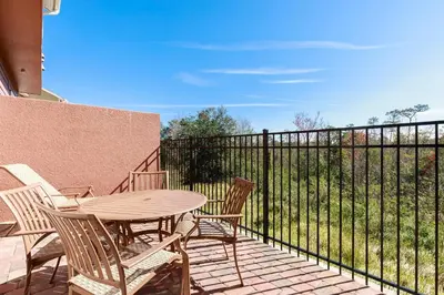 a patio with a table and chairs and a fence at 5min Disney Fantastic Family Villa SMV113 in Orlando