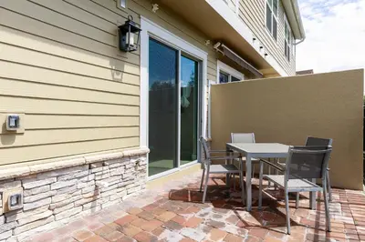 a patio with a table and chairs next to a building at Gorgeous Family Villa 114 in Orlando