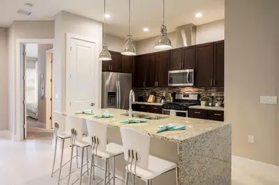 a kitchen with a large island with bar stools at Gorgeous Family Villa 114 in Orlando