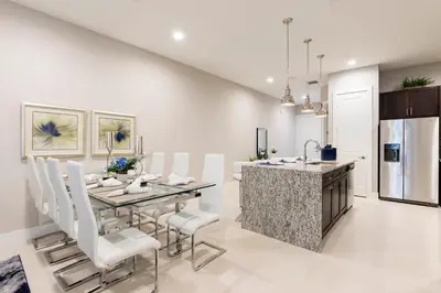 a kitchen and dining room with a table and chairs at 5min Disney Fantastic Townhome, BBQ 116 in Orlando