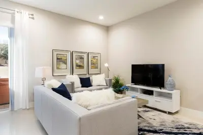 a living room with a white couch and a tv at 5min Disney Fantastic Townhome, BBQ 116 in Orlando