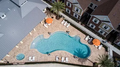 an overhead view of a swimming pool with chairs and umbrellas at 5min Disney Fantastic Townhome, BBQ 116 in Orlando