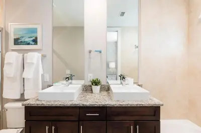 a bathroom with two sinks and a large mirror at Comfy Villa 5 Min to Dinsey! Hot Tub & BBQ in Orlando