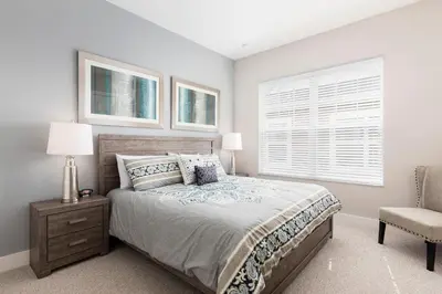 a bedroom with a bed and a chair and a window at Amazing Family Villa 5min Disney w BBQ 128 in Orlando