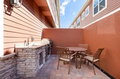 a patio with a table and chairs and a sink at Amazing Family Villa 5min Disney w BBQ 128 in Orlando