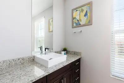 a bathroom with a white sink and a mirror at 5min Disney Lovely Villa Hot tub 130 in Orlando