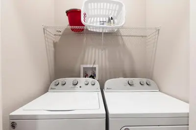 two white washing machines in a laundry room with a shelf at Precious Townhome w BBQ 131 in Orlando