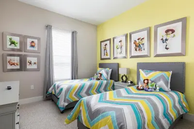 a bedroom with two beds and pictures on the wall at Beautiful Family Villa Patio area with BBQ 5min Disney in Orlando