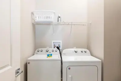 a small laundry room with two washer and dryer at Beautiful Family Villa Patio area with BBQ 5min Disney in Orlando