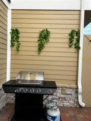 a grill with a sink on the side of a house at Beautiful Family Villa Patio area with BBQ 5min Disney in Orlando