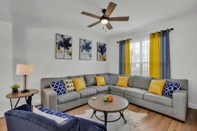 a living room with a couch and a ceiling fan at Large 6BR Themed Family Villa Near Disney world in Kissimmee