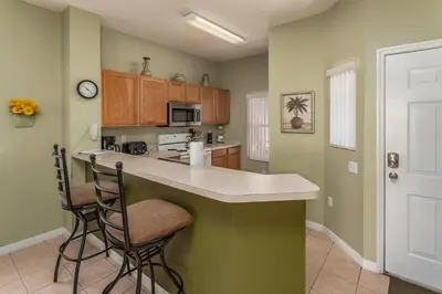 a kitchen with a counter and two stools at Emerald Island-RU1029 in Kissimmee