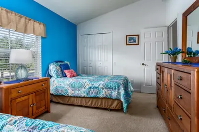 a blue bedroom with two beds and a dresser at Windsor Palms-RU831 in Kissimmee