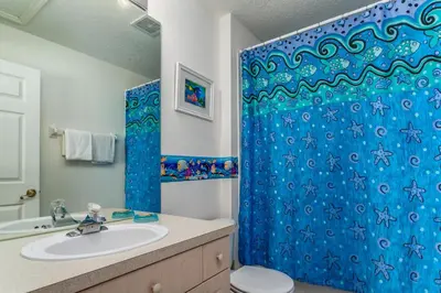 a bathroom with a blue shower curtain and a sink at Windsor Palms-RU831 in Kissimmee