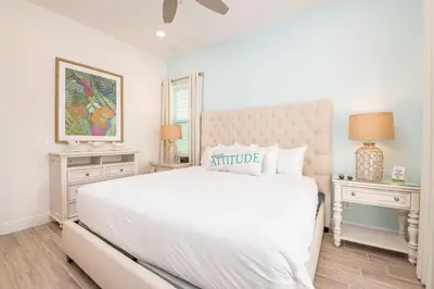 a white bedroom with a large bed and two night stands at Sea Breeze Cottage Near Disney With Margaritaville Resort & Island H20 Waterpark Access - 2982La in Orlando