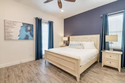 a bedroom with a large bed and blue walls at Sunny Yellow Cottage Near Disney With Margaritaville Resort & Island H2O Access - 3029Sp in Orlando