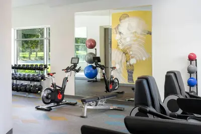 a gym with several exercise bikes and a mirror at The Celeste Hotel, Orlando, a Tribute Portfolio Hotel in Orlando