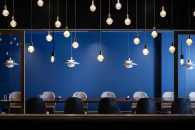 a blue room with tables and chairs and lights at The Celeste Hotel, Orlando, a Tribute Portfolio Hotel in Orlando