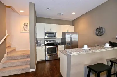 a kitchen with stainless steel appliances and a staircase at Great townhouse in gated community West Lucaya in Kissimmee