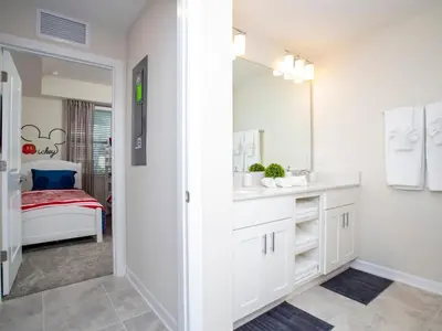 a white bathroom with a sink and a mirror at Marvelous 2 Bd Apt Close to Disney at Storey Lake 106 in Kissimmee
