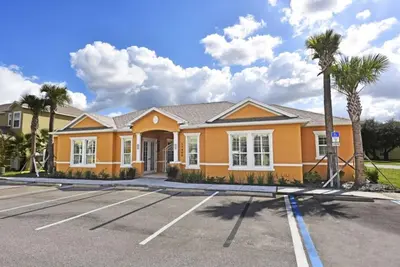 a yellow house with palm trees in a parking lot at Beautiful 3-Bed Villa 10 Minutes From Disney-17440 Serenity Resort townhouse in Orlando