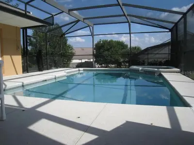 a large swimming pool in a building with a glass ceiling at Family Vacation Home With Pool and Spa Near Disney and Universal in Orlando