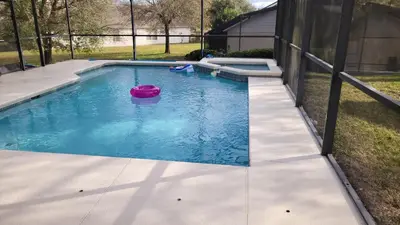 a pool with a pink frisbee in the water at Family Vacation Home With Pool and Spa Near Disney and Universal in Orlando