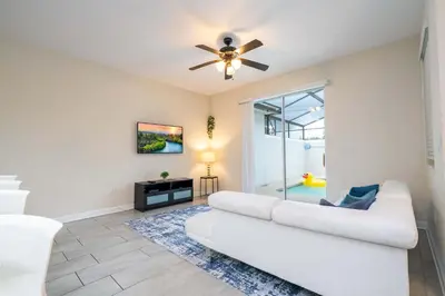a living room with a white couch and a ceiling fan at Gorgeous Four Bd w/ Pool close to Disney 5035 in Kissimmee
