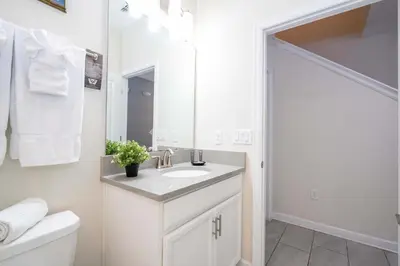a white bathroom with a sink and a mirror at Gorgeous Four Bd w/ Pool close to Disney 5035 in Kissimmee
