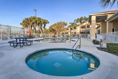 a swimming pool with a table and a picnic table at Kissimmee Condo with Resort Perks - 5 Mi to Disney! in Orlando