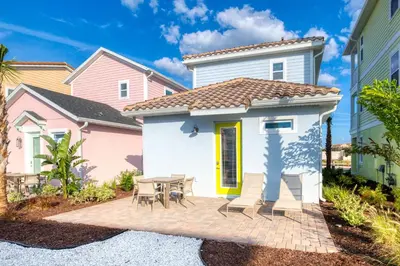 a small white house with a table and chairs at The Tiki Room - Beautiful Two Bedroom Cottage Near Disney With Margaritaville Resort & Island H20 Waterpark Access - 2954Sr in Orlando