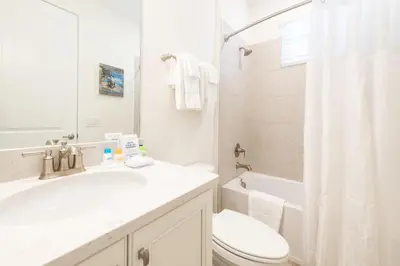 a white bathroom with a sink and a toilet at Lake View Cottage With Private Pool Near Disney And Margaritaville Resort & Island H2O Access - 8089Su in Orlando