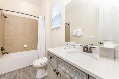 a bathroom with a sink and a toilet and a tub at Sandy Shores Cottage Near Disney With Margaritaville Resort & Island H2O Access - 8077Kd in Orlando