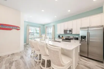 a kitchen with a white counter and a refrigerator at Seabreeze Cottage Near Disney With Margaritaville Resort & Island H2O Access - 8073Kd in Orlando