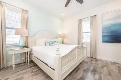 a white bedroom with a bed and a table at Seabreeze Cottage Near Disney With Margaritaville Resort & Island H2O Access - 8073Kd in Orlando