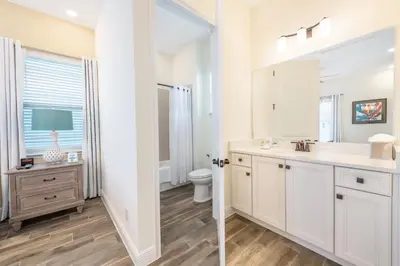 a white bathroom with a sink and a toilet at Coral Cottage Near Disney With Margaritaville Resort & Island H2O Access - 8063Kd in Orlando
