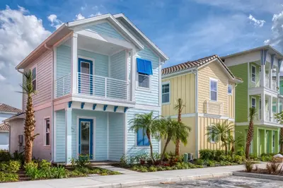 a row of houses with palm trees in front at Tropical Paradise Cottage Near Disney With Margaritaville Resort & Island H2O Access - 8061Kd in Orlando