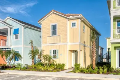 a row of houses with palm trees in a street at Life Is Good Cottage Near Disney With Margaritaville Resort & Island H2O Access - 8059Kd in Orlando