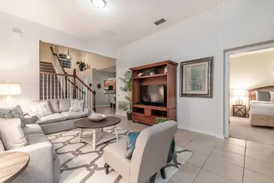 a living room with a couch and a tv at Spacious Home wPrivate PoolSpa & FREE Waterpark in Orlando