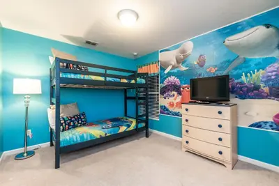 a bedroom with a bunk bed and a television at Spacious Home wPrivate PoolSpa & FREE Waterpark in Orlando