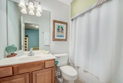 a bathroom with a toilet and a sink and a mirror at Spacious Home wPrivate PoolSpa & FREE Waterpark in Orlando