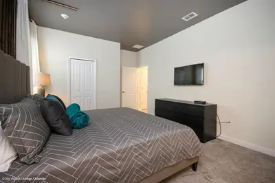 a bedroom with a bed and a tv on a wall at 2911 Fable Street in Kissimmee