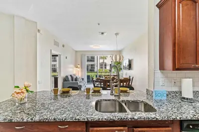 a kitchen with a sink and a living room at First floor Vista Cay Condo wFREE Resort Access in Orlando