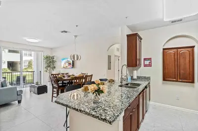 a kitchen and living room with a counter and a table at First floor Vista Cay Condo wFREE Resort Access in Orlando