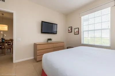 a bedroom with a bed and a flat screen tv at Cozy Condo wPrivate Balcony & FREE Resort Access in Orlando